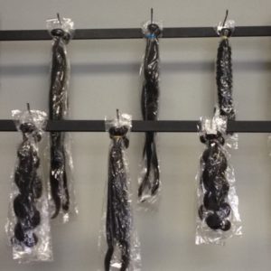 A bunch of black olives hanging on a rack