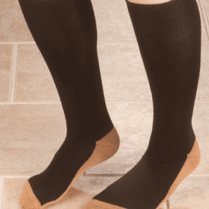 A person wearing black and tan socks standing on the floor.