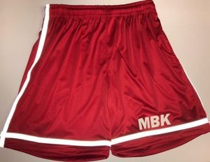 A pair of red shorts with white trim and the letters mbk.