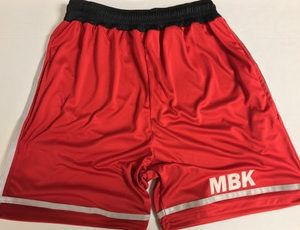 A pair of red shorts with the mbk logo on it.