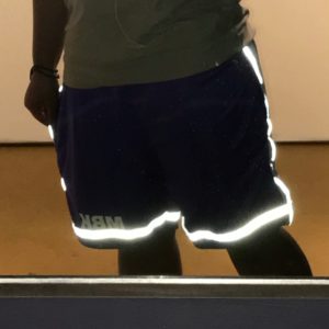 A man wearing reflective shorts and a white shirt.