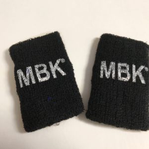 A pair of black wrist bands with mbk written on them.