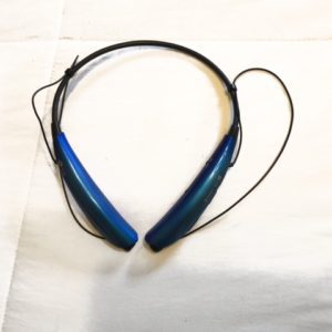 A blue and black headphones sitting on top of a white sheet.