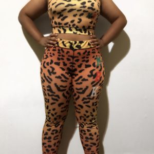 A woman standing in front of a wall wearing animal print clothing.